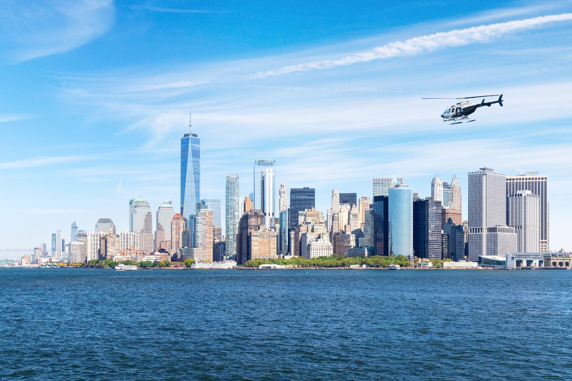 Helicopter flying above Manhattan skyline, bypassing heavy traffic below